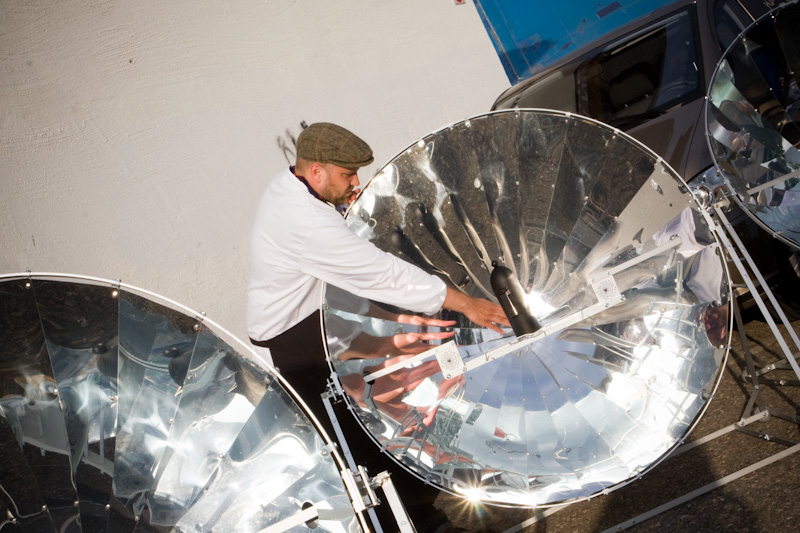Antto Melasniemi asettelee aurinkokeitint&auml; oikeaan kulmaan kahvinkeittoa varten