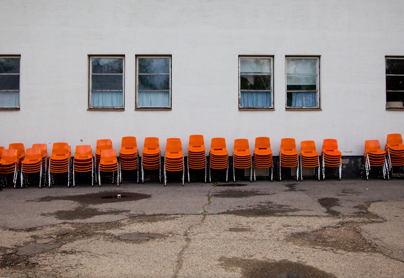 Pikkuteltan tuolit sievässä rivissä koulun seinustalla
