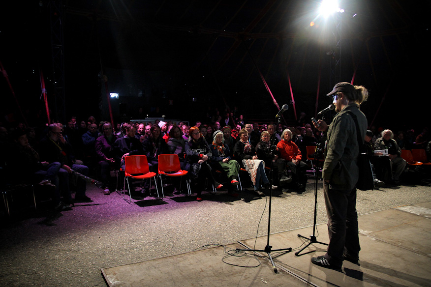 Eero Tammi lukemassa Rax Rinnekankaan tekstariterveisiä Romanssin yleisölle